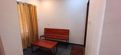 a wooden bench in a room with a door at Empire Single Bedroom Villa with Common Pool in Meenangadi