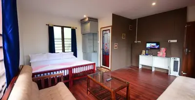 a living room with a bed and a couch at Greens Vista Homestay Wayanad Near Natural Stream and Pool in Panamaram