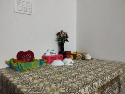 a bed with a bedspread with a vase on it at SHI Triveni 1BHK at Coimbatore Outskirts in Irugūr