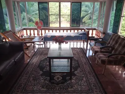 a living room with a couch and a table and chairs at Pournami Home Stay in Trichūr