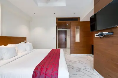 a bedroom with a bed and a flat screen tv at Hotel Vilvah in Coimbatore