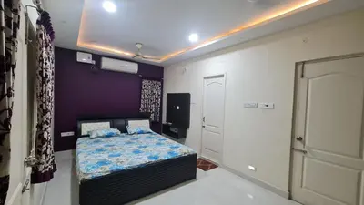 a bedroom with a bed and a purple wall at Kamalam 3BHK Villa 1AC and 2 Non AC Bedrooms in Coimbatore