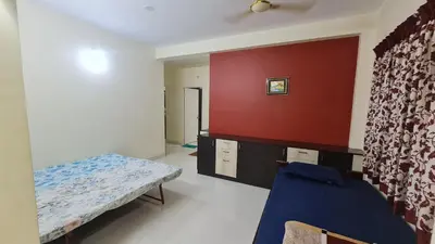a room with a bed and a red wall at Kamalam 3BHK Villa 1AC and 2 Non AC Bedrooms in Coimbatore