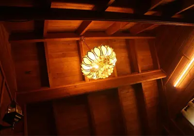 a chandelier hanging from the ceiling of a room at Joy Eco Woodhouse - 3 Bhk House in Ooty