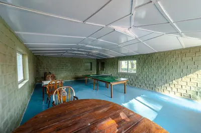a room with a ping pong table and chairs at Harris Holiday Inn in Vālpārai