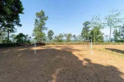 a soccer net on a dirt field with trees at Harris Holiday Inn in Vālpārai
