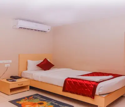 a bedroom with a bed and a air conditioner at Hotel Vinayaga Tiruppur in Tiruppūr