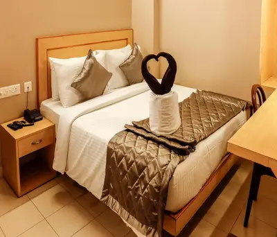 a hotel room with a bed with a heart on it at Hotel Vinayaga Tiruppur in Tiruppūr