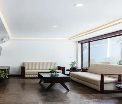 a living room with two couches and a table at Hotel Vinayaga Tiruppur in Tiruppūr