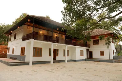 a large white building with a tree in front of it at Best Heritage Home in Iritti