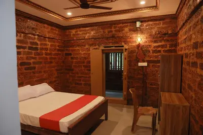 a bedroom with a bed and a table and a chair at Best Heritage Home in Iritti