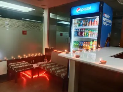 a bar with two benches and a drink cooler at Hotel Sapthagiri Nest in Coimbatore
