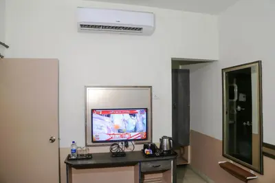 a room with a tv and a table with a tv at Hotel Sapthagiri Nest in Coimbatore