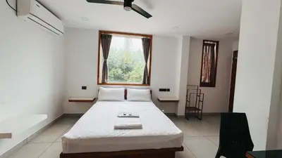 a bedroom with a large white bed with a window at Rose Garden at Rajagiri Hospital in Ernakulam