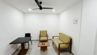 a room with two chairs and a table and a ceiling fan at Rose Garden at Rajagiri Hospital in Ernakulam