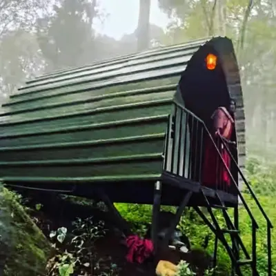 a small green house with a person sitting in it at Vattavada Jungle Resort in Munnar