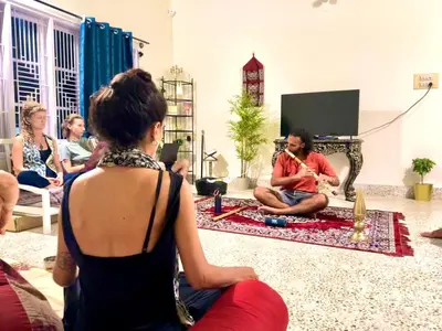 a group of people sitting in a living room playing instruments at Palace Hostel by Borrbo in Mysore