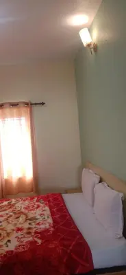 a bedroom with a bed with a red blanket and a window at Stay awhile in Ooty
