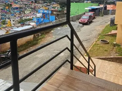 a balcony with a view of a city with cars at Stay awhile in Ooty