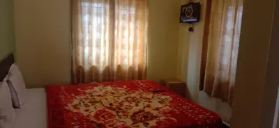 a bedroom with a bed with a red and white blanket at Stay awhile in Ooty