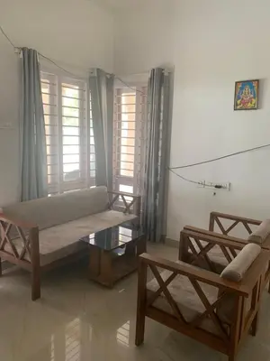 a living room with a couch and a coffee table at Casa Ganesha beach villa in Irimbranallūr
