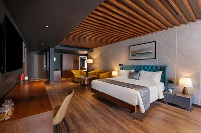 a bedroom with a bed and a living room at Sterling Athirappilly in Athirappilly