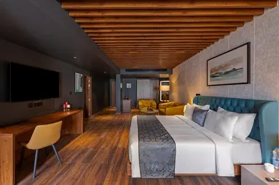 a hotel room with a large bed and a television at Sterling Athirappilly in Athirappilly