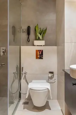 a bathroom with a toilet and a shower and a sink at Sterling Athirappilly in Athirappilly
