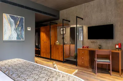 a bedroom with a desk and a television in a room at Sterling Athirappilly in Athirappilly
