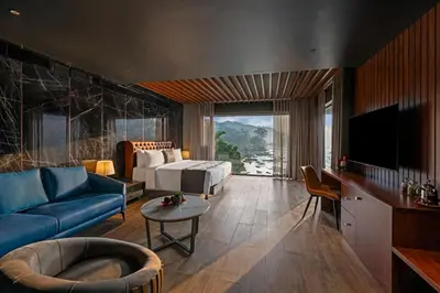 a living room with a blue couch and a tv at Sterling Athirappilly in Athirappilly