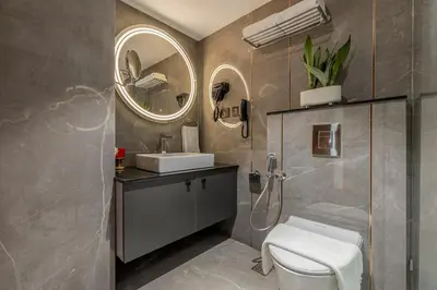 a bathroom with a toilet and a sink and a mirror at Sterling Athirappilly in Athirappilly