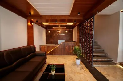 a lobby with a couch and a table and stairs at ARIAT AVENUE in Wayanad