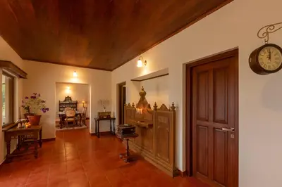 a hallway with a clock on the wall and a door at Emerald by Nature Resorts and Stays in Ooty