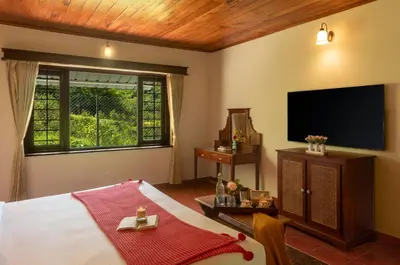a bedroom with a large bed and a television at Emerald by Nature Resorts and Stays in Ooty