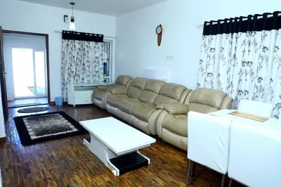 a living room with a couch and a table at HAILSTONE HOME STAY in Ooty