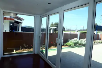 a room with sliding glass doors looking out onto a yard at HAILSTONE HOME STAY in Ooty