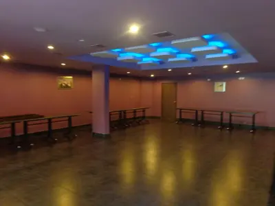 a room with tables and blue lights on the ceiling at HOTEL SRIVATSA REGENCY in Pudunagaram
