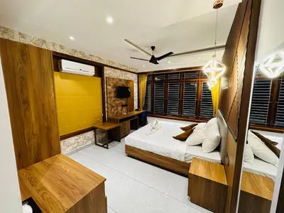 a bedroom with a bed and a yellow wall at Farm Fort Resort in Kozhikode