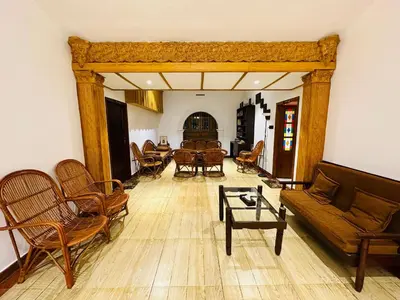 a living room with chairs and a couch and a table at Farm Fort Resort in Kozhikode