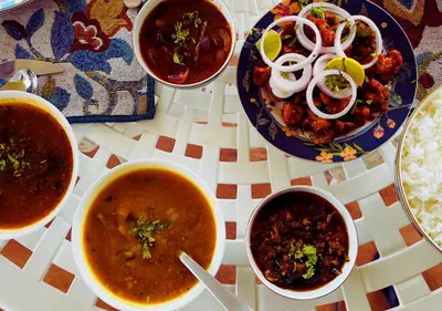 a group of bowls of soup and rice on a table at Wild Pastures by Nature Resorts and Stays in Masinagudi