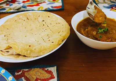 a plate of food with a bowl of soup and a tortilla at Wild Pastures by Nature Resorts and Stays in Masinagudi