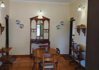 a dining room with a table and a bed at Wild Pastures by Nature Resorts and Stays in Masinagudi