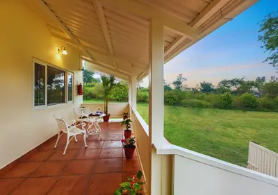a screened in porch with a table and chairs on it at Wild Pastures by Nature Resorts and Stays in Masinagudi