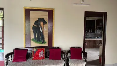 a living room with a couch with red pillows at CITADEL HOLIDAY HOME in Vythiri