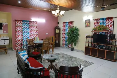 a room with a table and chairs and a tv at CITADEL HOLIDAY HOME in Vythiri