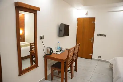 a room with a table and a mirror and a bedroom at Silverstone Inn in Nedumbassery