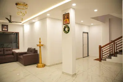 a living room with a couch and a clock on a wall at Silverstone Inn in Nedumbassery