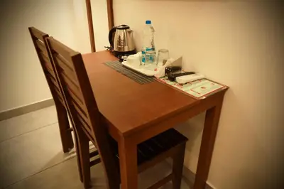 a wooden table and chairs with a tea kettle on it at Silverstone Inn in Nedumbassery