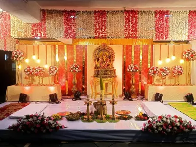 a banquet hall with a table with flowers on it at Hotel Mangala Temple View in Guruvāyūr