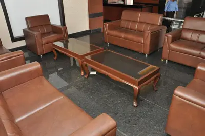a room with leather chairs and a coffee table at Hotel Royal Chambers in Coimbatore
